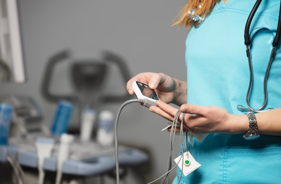 Healthcare worker holding a Personal Ambulatory Electrocardiograph